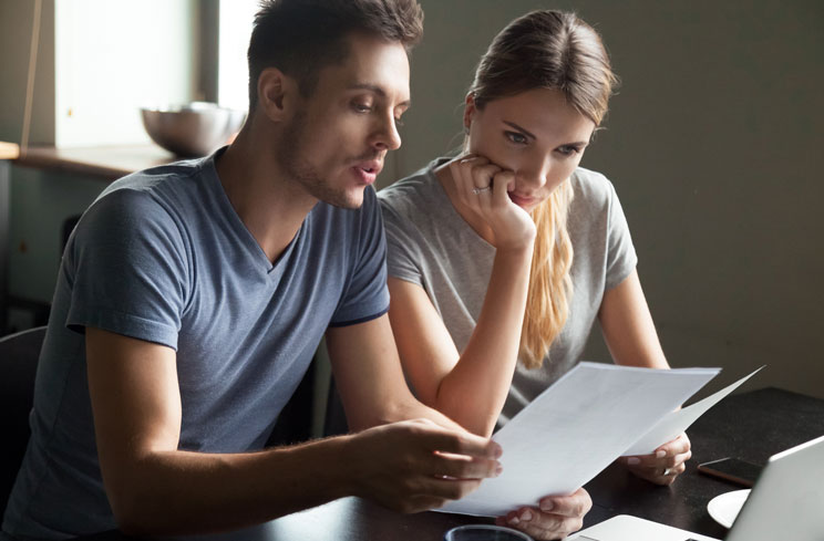 Man and woman looking through credit statements